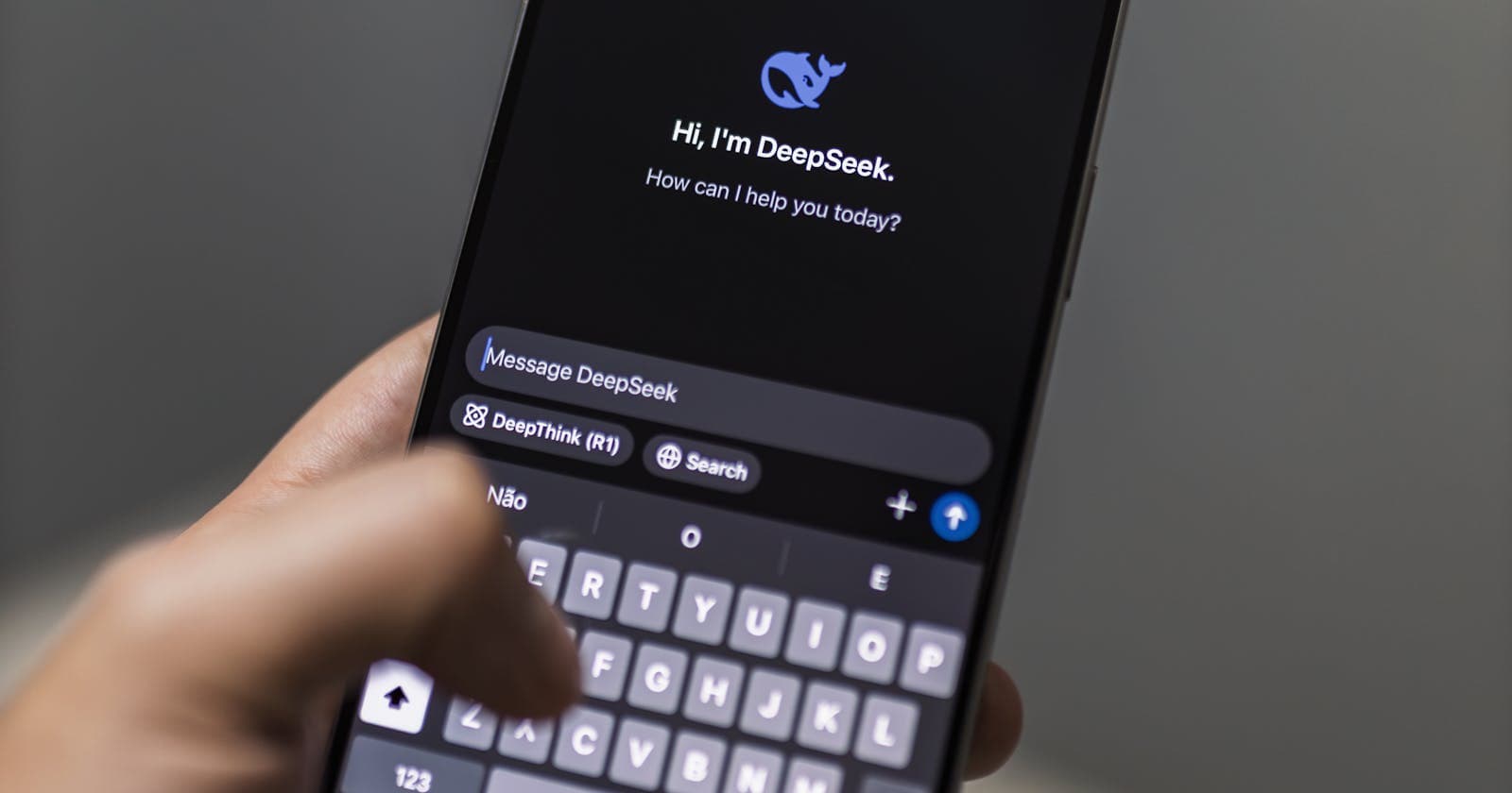 Hand holding a phone with an AI chat assistant