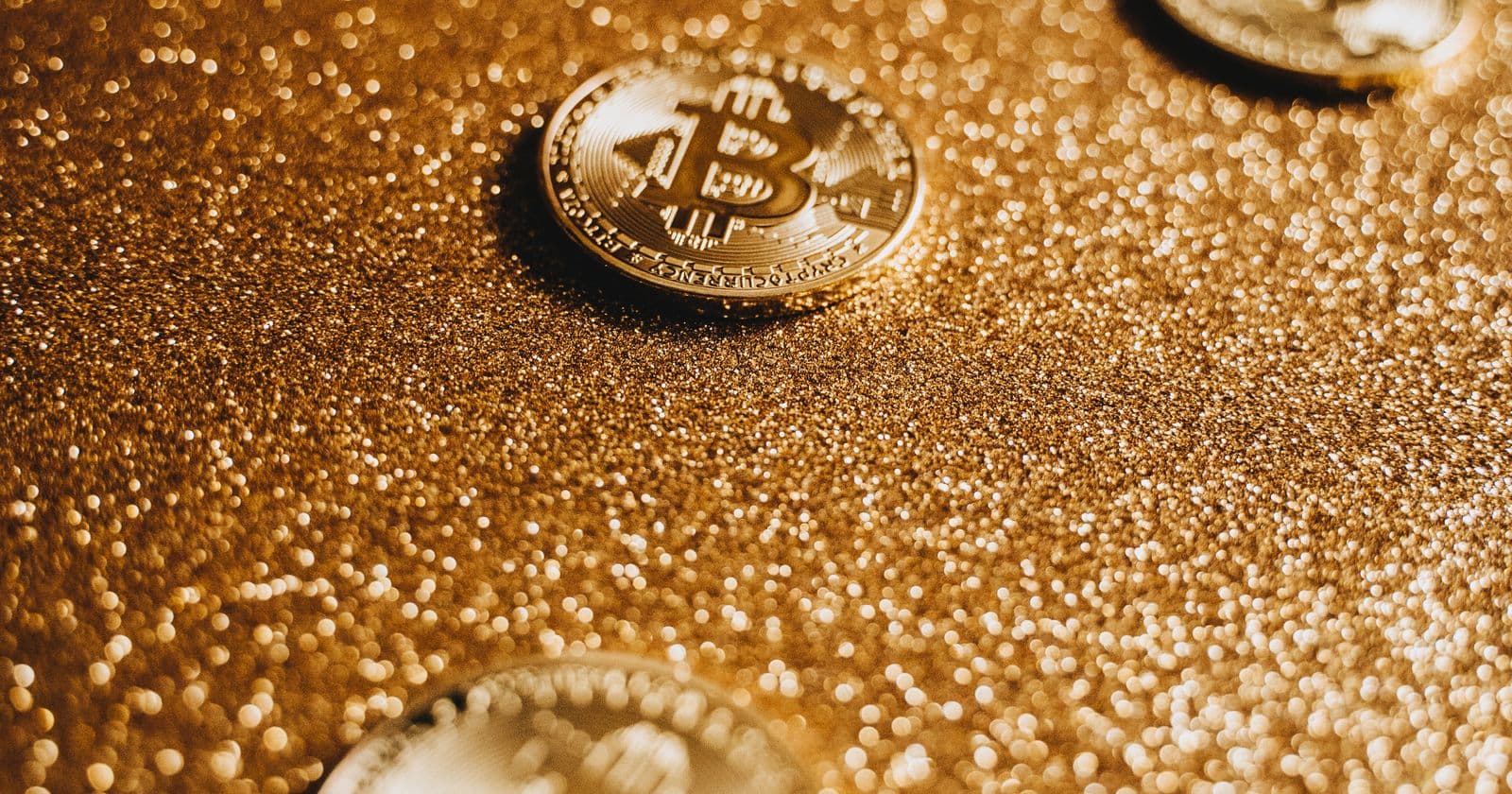 Gold bitcoin coin on a shimmering surface