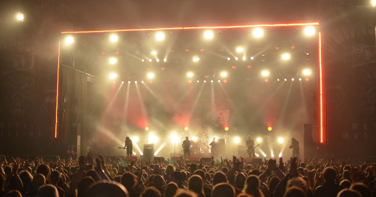 Band performing live on a stage with bright lights