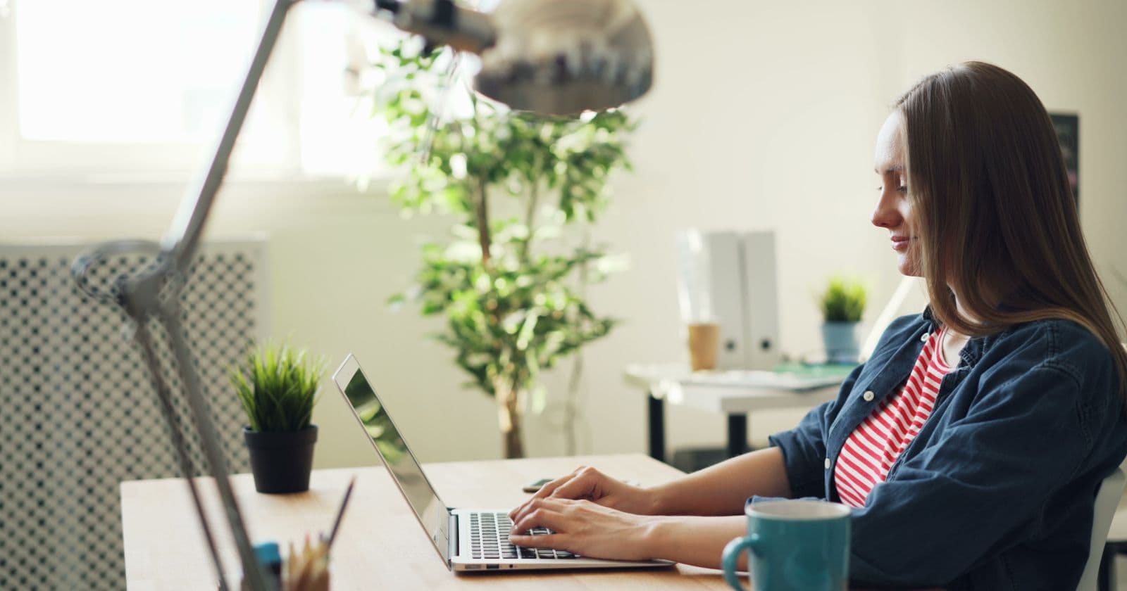 Person smiling while working on a laptop