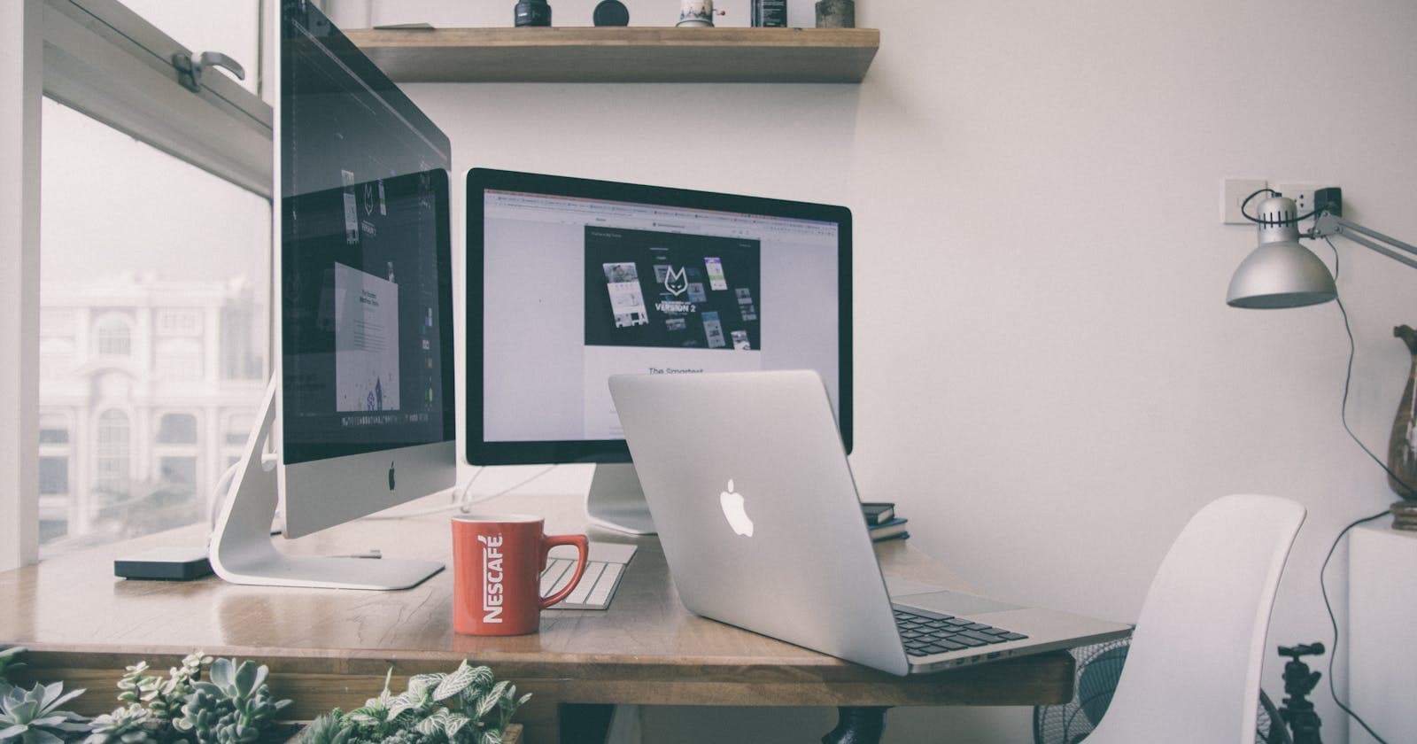 Clean home-office desk with a laptop and monitor