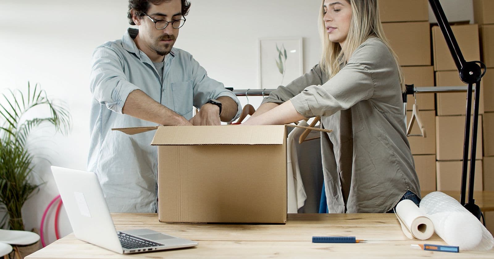 Couple packing an online store order into a cardboard box